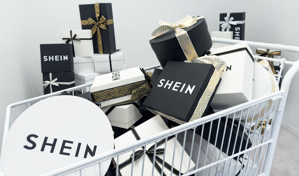 Carrinho de Compras com Várias Caixas da Shein em sua Proximidade